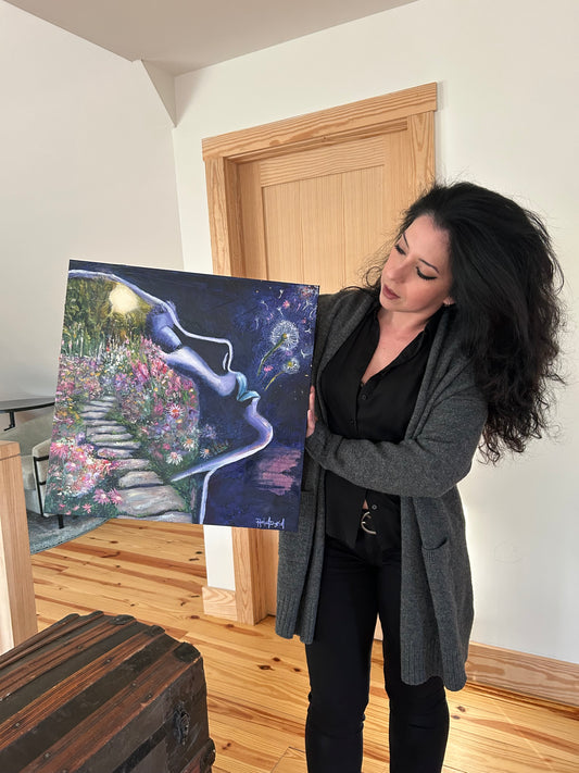 Artist Rachel Ingrid holding her original painting titled Words and Worlds